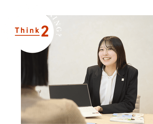 女性社員がお客様にパソコンを見せながら提案している様子